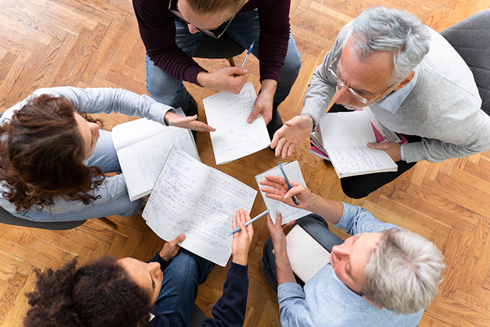 group of people with notes and pens